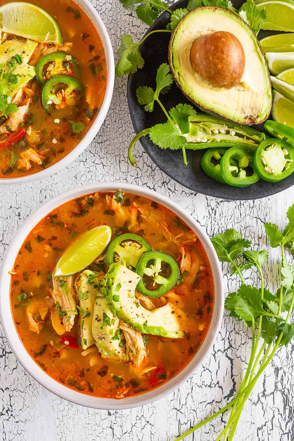 Chicken Avocado Cilantro Lime Soup in a bowl topped with avaocado.