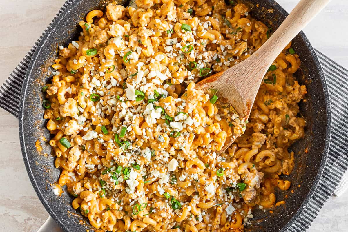 One Pot Buffalo Chicken Pasta in a skillet with a wooden spoon. 