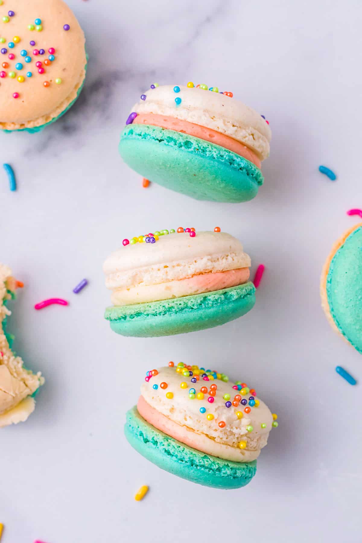 Birthday Cake Macarons laying on a marble board. 
