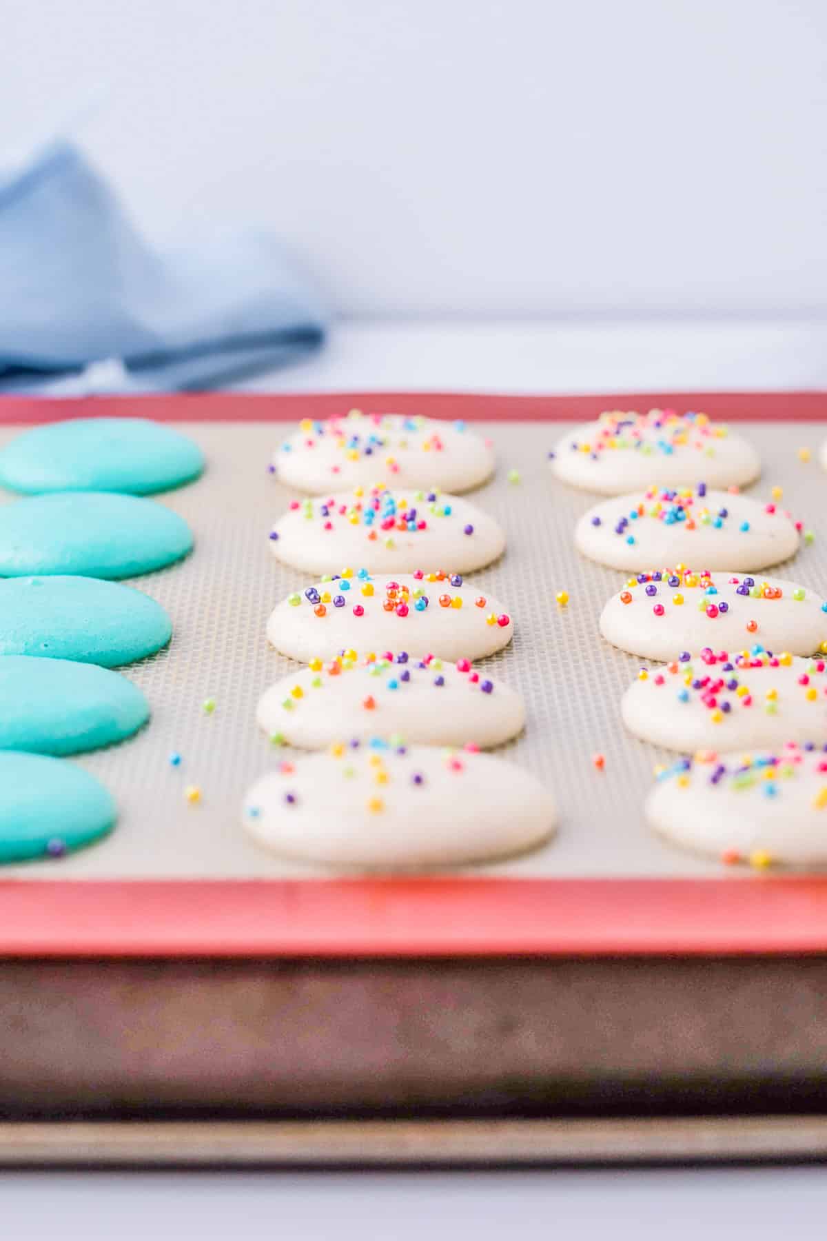 Macarons drying out on a sheet pan. 