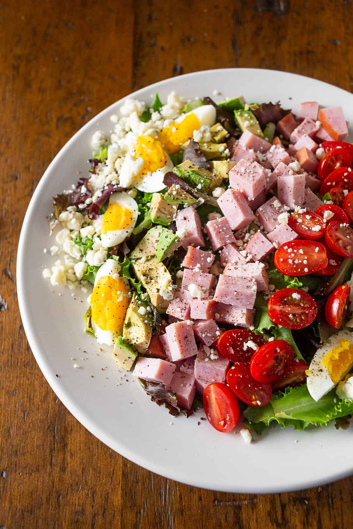 Ham Cobb Salad in a white bowl on a table.
