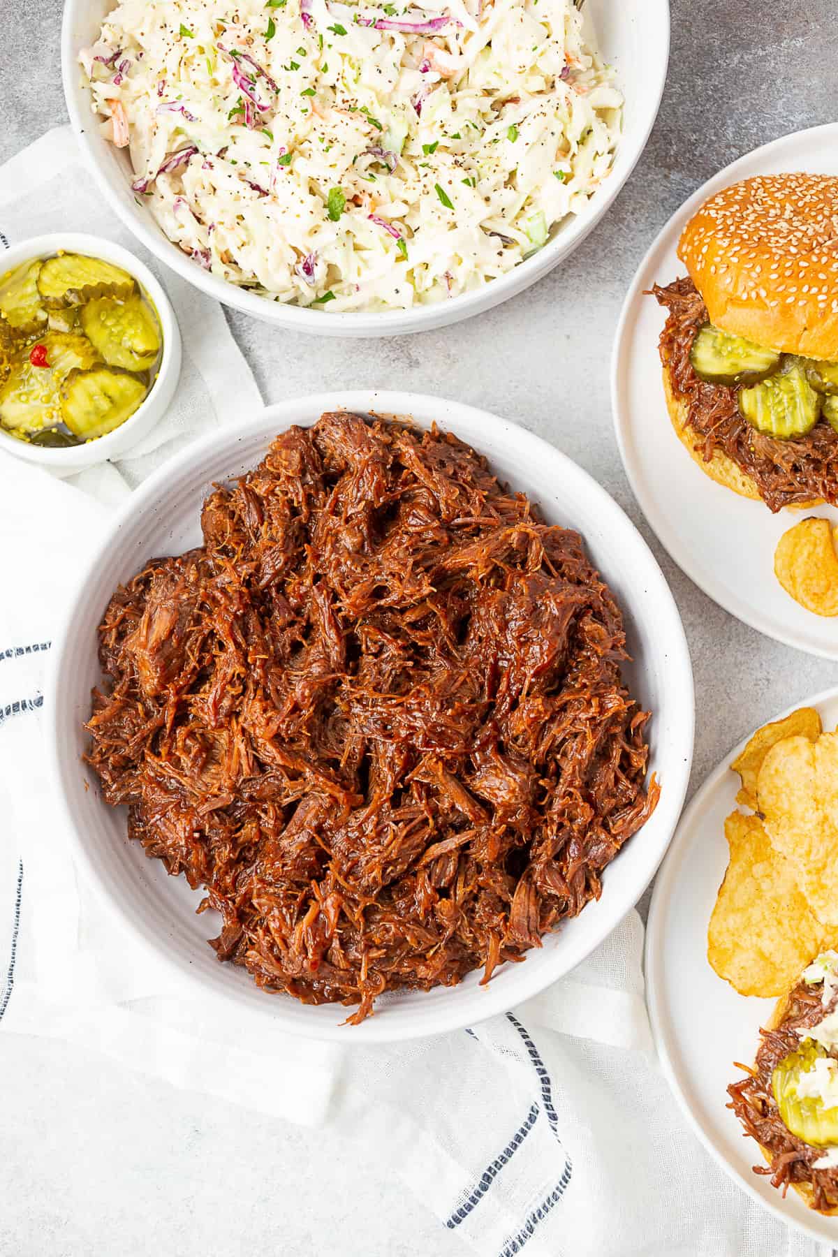 BBQ Shredded Beef in a large white bowl served with coleslaw. 