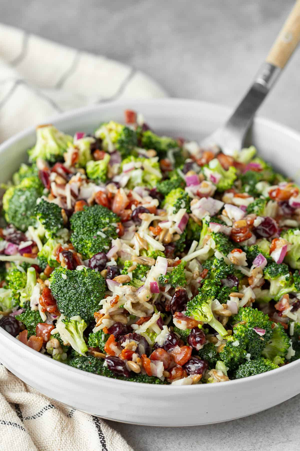 Broccoli bacon salad in a white ceramic bowl. 