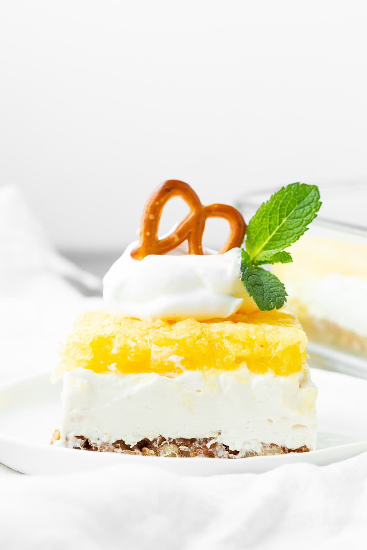 Pineapple Pretzel Salad topped with Cool Whip. 