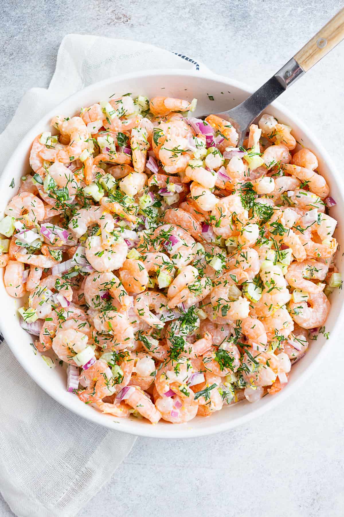 Classic Shrimp Salad in a bowl topped with extra herbs.