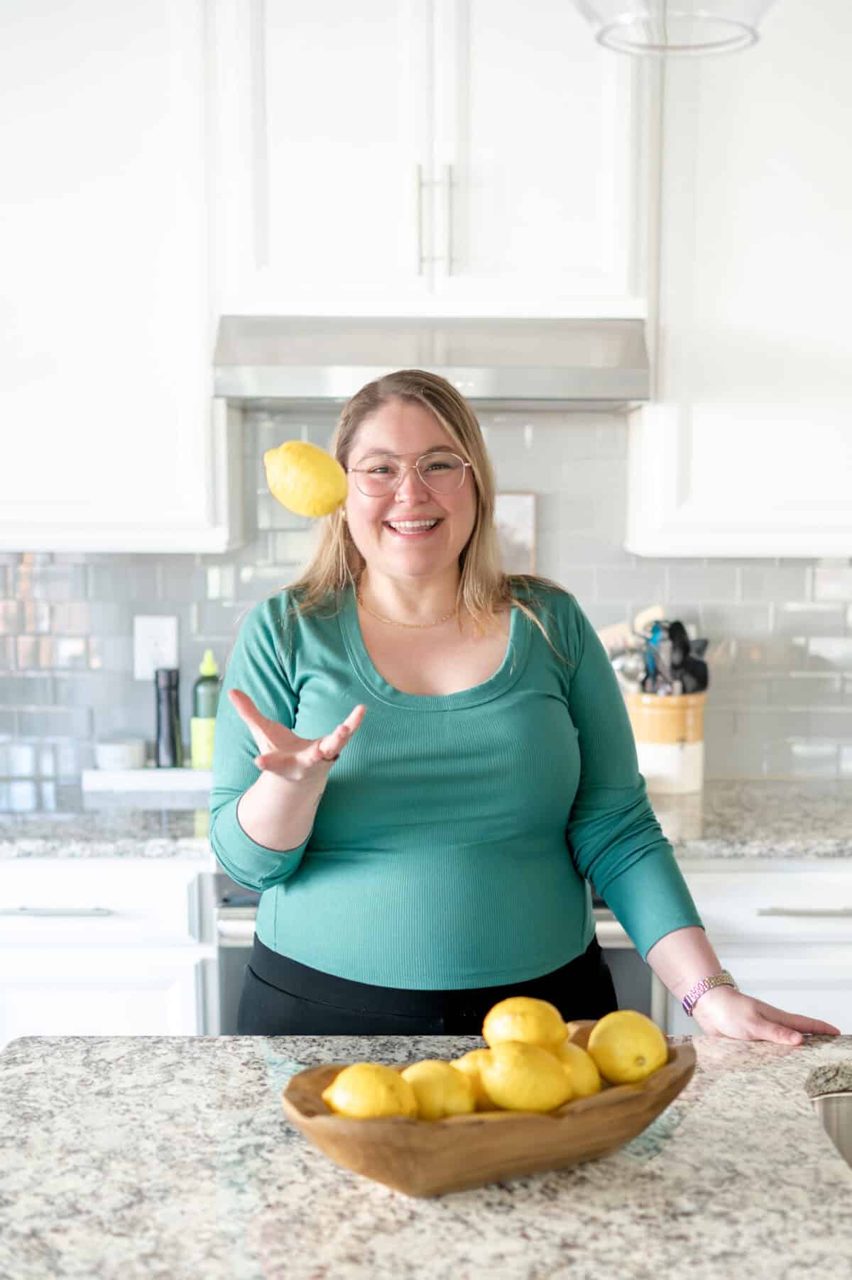 Girl in a green shirt catching a lemon in the air.