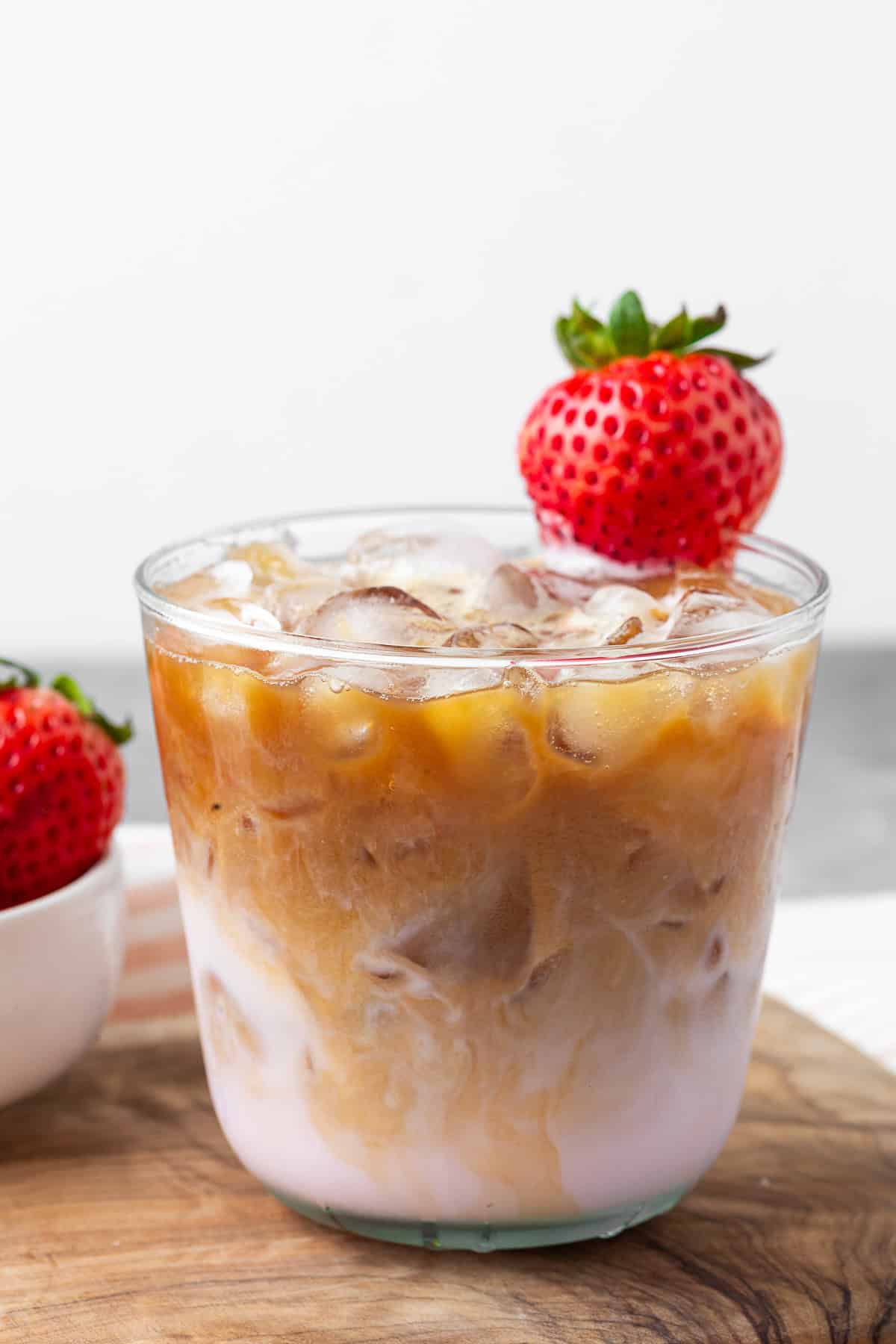 A glass with strawberry milk and espresso in it.