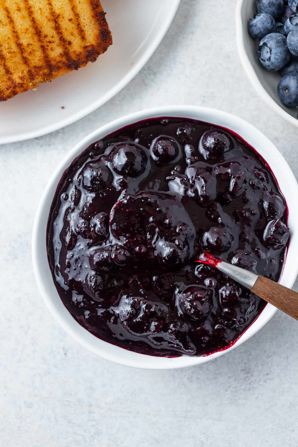 Blueberry Compote in a bowl with a spoon.