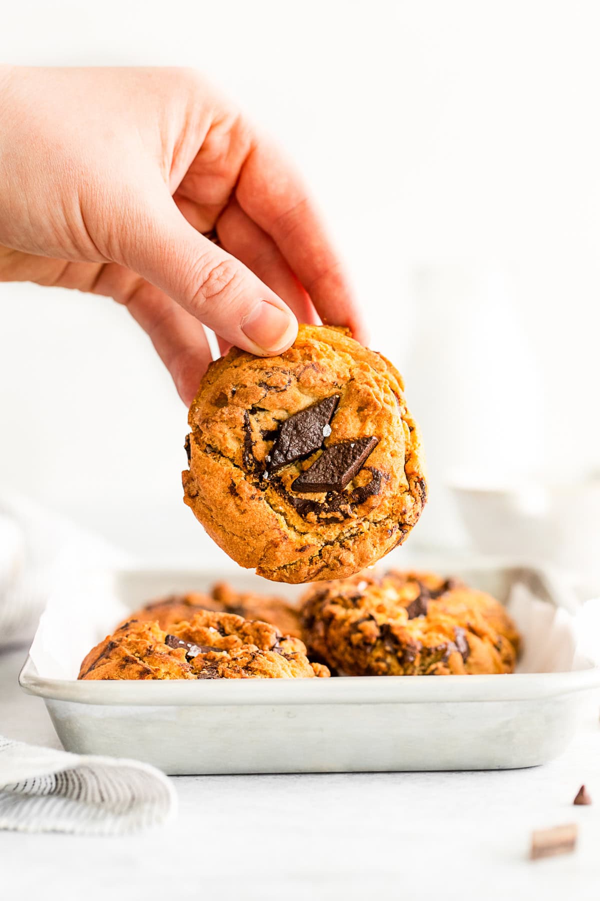 A hand holding a Air Fryer Chocolate Chip Cookie. 