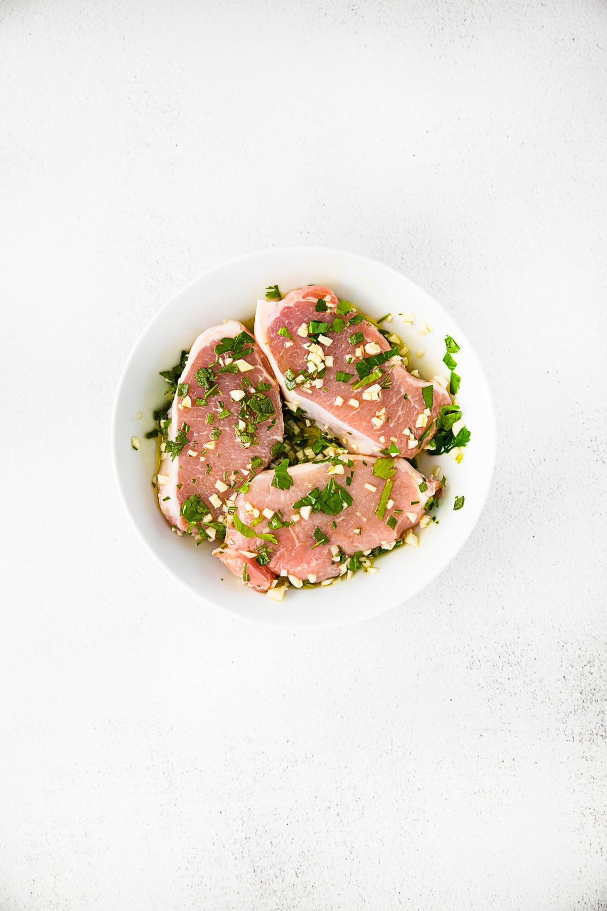 Marinating pork chops in a bowl. 