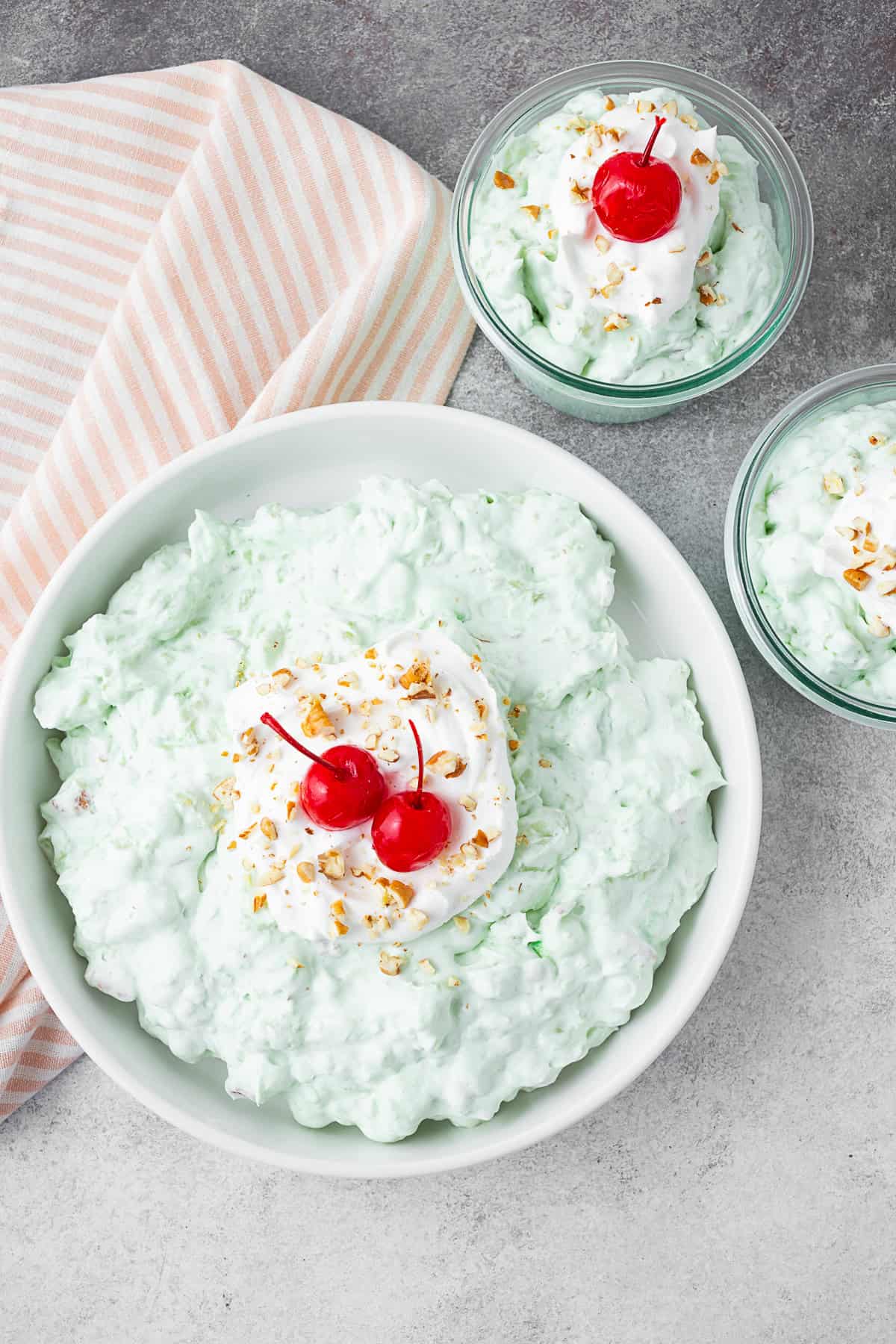 Watergate Salad in a large bowl with 2 smaller bowls on the side. 
