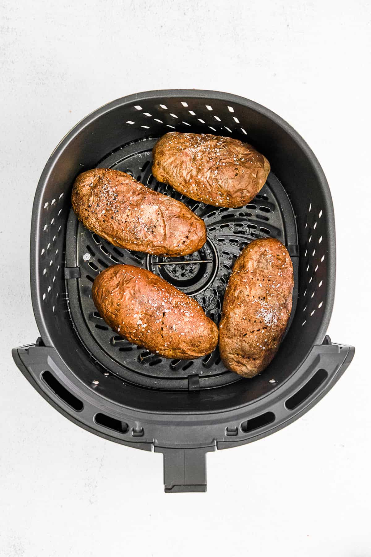Air Fryer Baked Potatoes in an air fryer basket.
