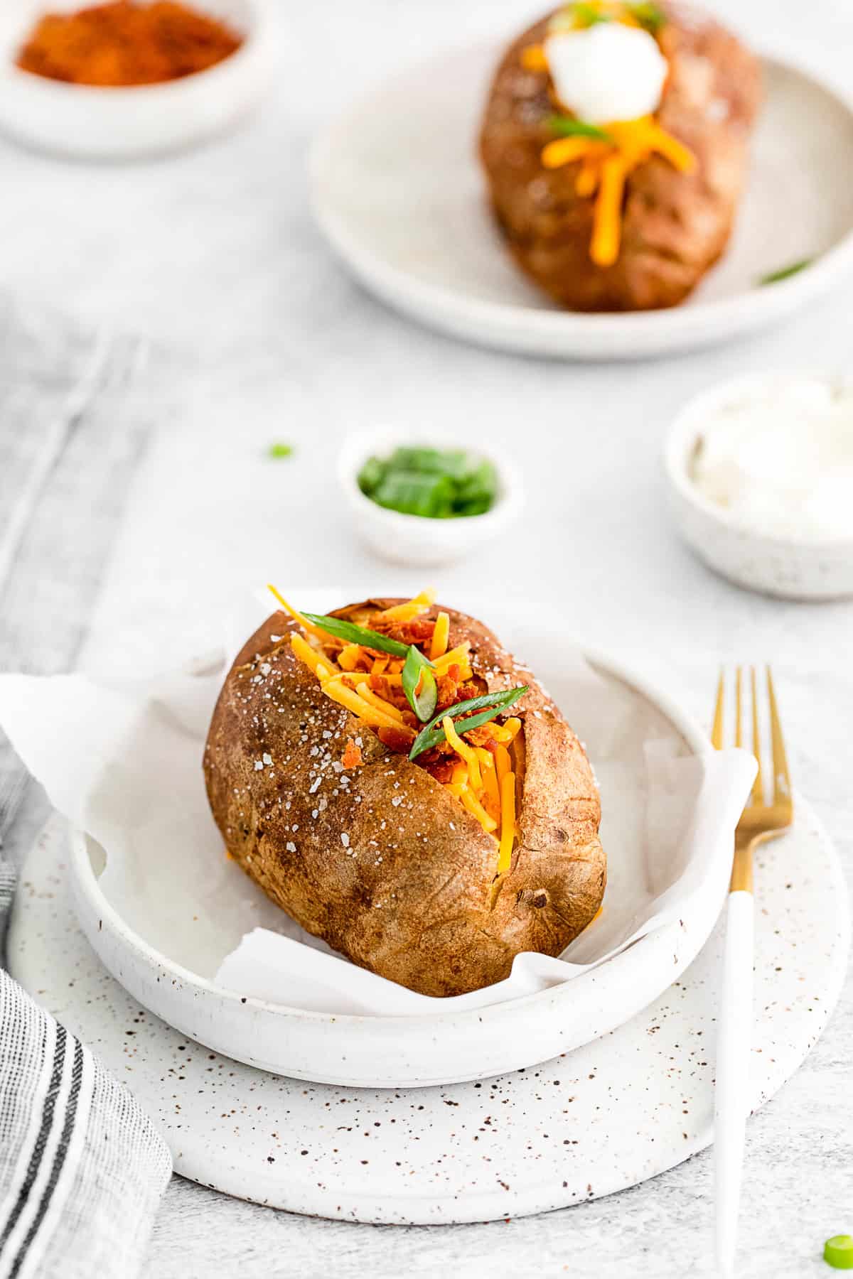 Air Fryer Baked Potatoes on a plate with a fork.