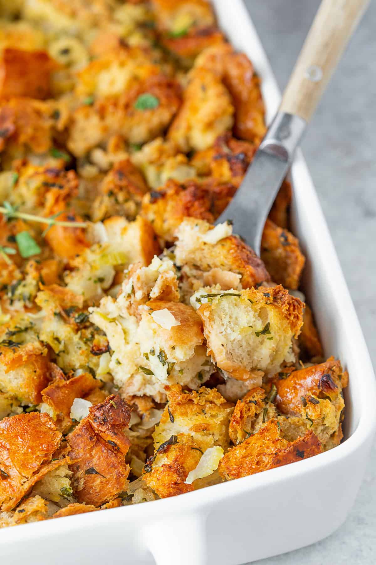 A spoon taking out a serving of Herb Stuffing. 