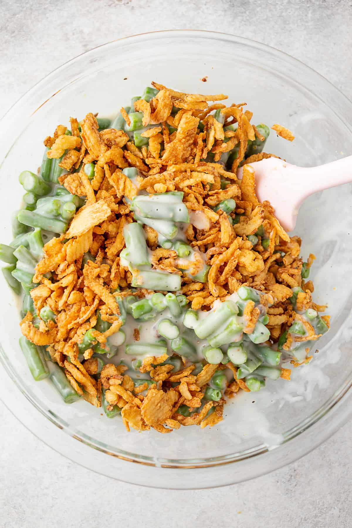 Green Bean Casserole being mixed in a bowl.