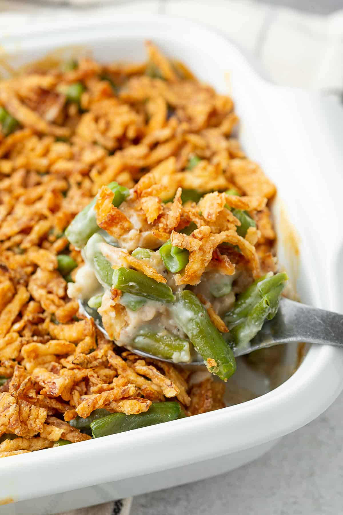 Green Bean Casserole getting spooned out of dish.