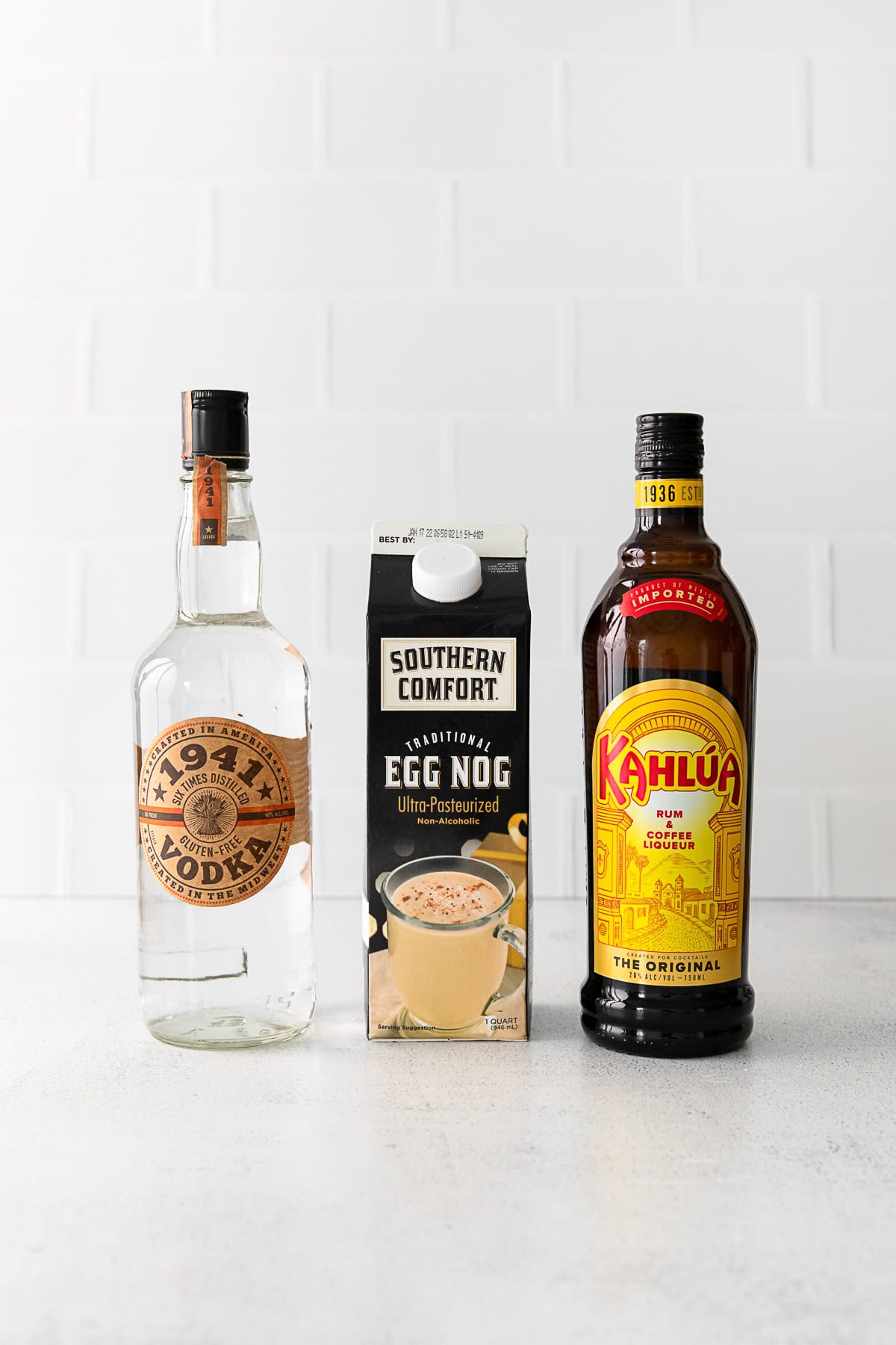 vodka, kahlua, and eggnog on a table. 