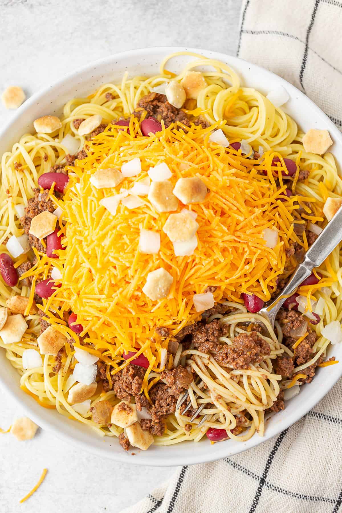 Cincinnati Chili in a bowl served with a fork. 