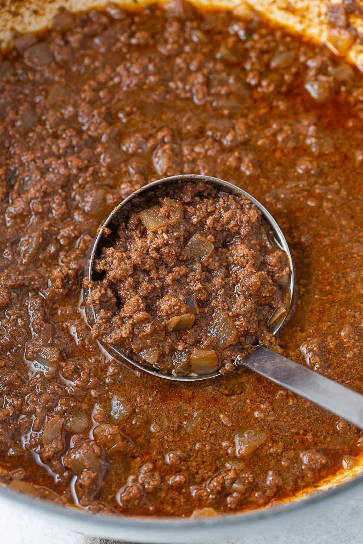 Cincinnati Chili in a pot being scooped out with a ladle. 